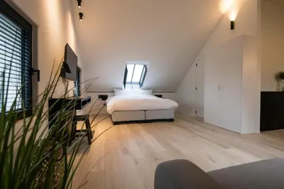 a bedroom with a bed in the middle of a room at B&B Amelhof in Meise