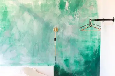 a bedroom with a green wall with a shower at The Hide in Ghent