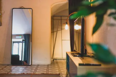 a living room with a tv and a mirror at The Hide in Ghent