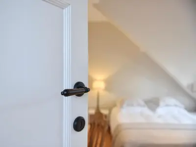 a white door with a bed in a bedroom at B&B Salve in Brussels
