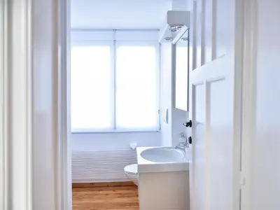 a white bathroom with a sink and a window at B&B Salve in Brussels