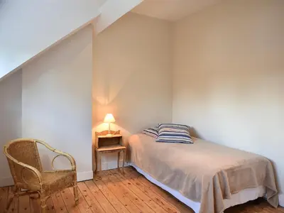 a bedroom with a bed and a chair and a lamp at B&B Salve in Brussels