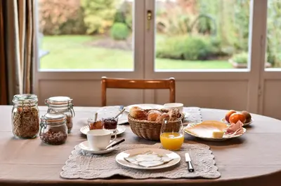 a table with a breakfast of bread and orange juice at B&B Salve in Brussels