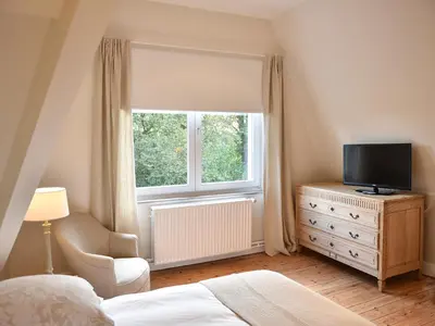 a bedroom with a bed and a television and a window at B&B Salve in Brussels