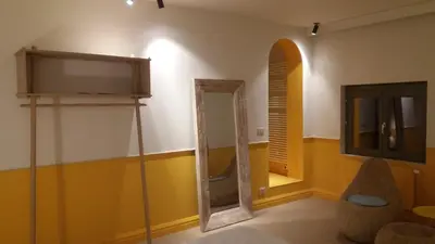 a bathroom with a mirror and a tv on the wall at B&B La Corderie in Hamme