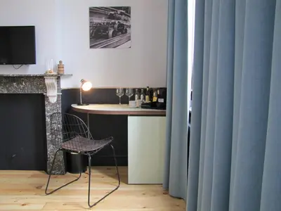 a table and a chair in a room with blue curtains at B&B La Corderie in Hamme
