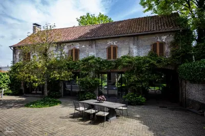 a table and chairs in front of a building at B&B La Corderie in Hamme