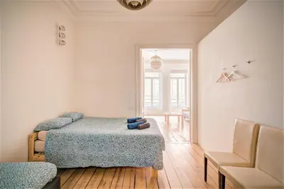 a bedroom with two beds and a chair at The Greenplace Lodge. Apartment in Heart of Antwerp. in Antwerp