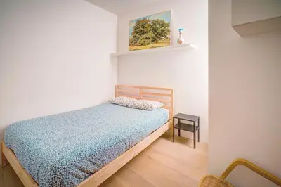 a bedroom with a bed with a blue comforter at The Greenplace Lodge. Apartment in Heart of Antwerp. in Antwerp