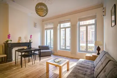 a living room with a couch and a table at The Greenplace Lodge. Apartment in Heart of Antwerp. in Antwerp