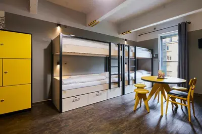 a bedroom with a bunk bed and a table and chairs at MEININGER Hotels Bruxelles City Center in Brussels