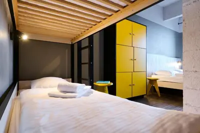 a bedroom with a large bed with yellow cabinets at MEININGER Hotels Bruxelles City Center in Brussels