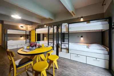 a room with a table and two bunk beds at MEININGER Hotels Bruxelles City Center in Brussels