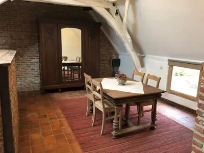 a dining room with a wooden table and chairs at Trommelhoeve Farm Lofts in Boechout