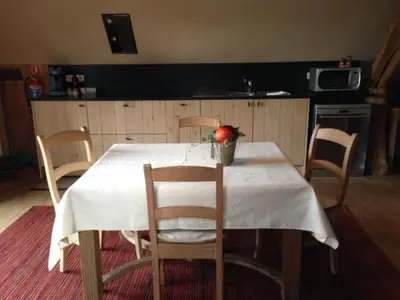 a kitchen with a table with a white table cloth on it at Trommelhoeve Farm Lofts in Boechout