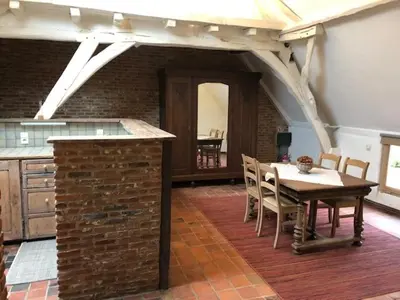 a kitchen and dining room with a table and chairs at Trommelhoeve Farm Lofts in Boechout