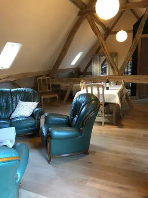 a living room with two chairs and a table at Trommelhoeve Farm Lofts in Boechout