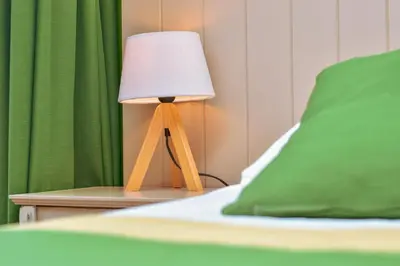 a lamp sitting on a table next to a bed at B&B Fruithof Tack in Sint-Gillis-Waas