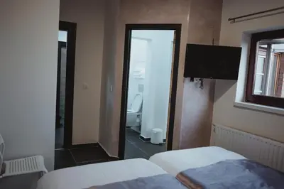 a bedroom with a mirror and a bathroom with a toilet at Hôtel onyx expo in Brussels