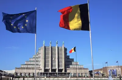 three flags are flying in front of a building at Hôtel onyx expo in Brussels