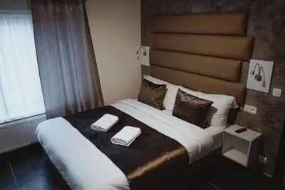 a bedroom with a large bed with two napkins on it at Hôtel onyx expo in Brussels