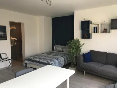 a living room with a bed and a couch at Au Calme in Sint-Genesius-Rode