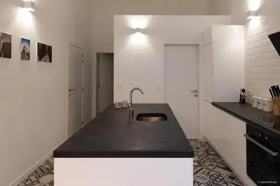 a kitchen with a black counter and a sink at House Forelle Gent in Ghent