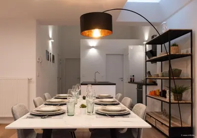 a dining room with a white table and chairs at House Forelle Gent in Ghent