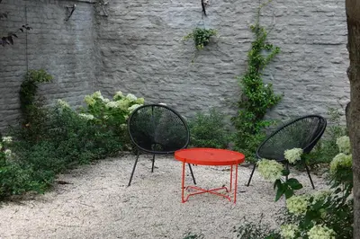 two chairs and a red table in front of a wall at House Forelle Gent in Ghent