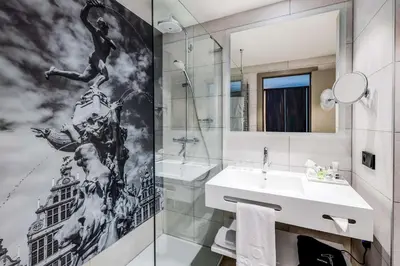 a bathroom with a sink and a mirror at NH Collection Antwerp Centre in Antwerp
