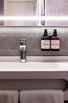 two bottles of soap sitting on a bathroom sink at NH Collection Antwerp Centre in Antwerp