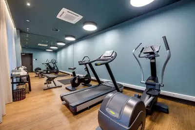 a gym with several treadmills and exercise bikes at NH Collection Antwerp Centre in Antwerp