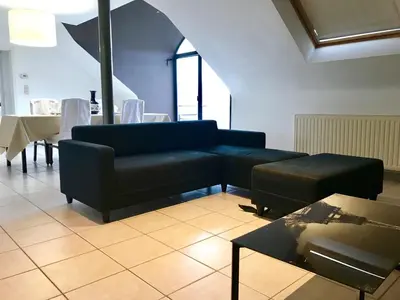 a living room with a couch and a table at FANTASIA a spacious beautiful apartment & affordable in Nossegem
