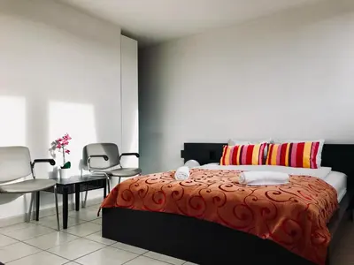 a bedroom with a bed and a table and chairs at FANTASIA a spacious beautiful apartment & affordable in Nossegem