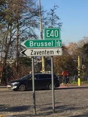 a street sign on the side of a road with a car at FANTASIA a spacious beautiful apartment & affordable in Nossegem