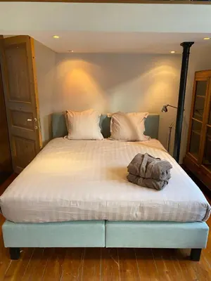 a bedroom with a large bed with a stuffed animal on it at Artist's Loft & Garden in Ghent