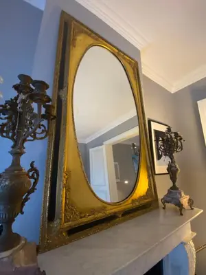 a gold mirror sitting on a mantle in a room at Artist's Loft & Garden in Ghent