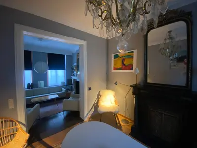 a bedroom with a bed and a mirror and a living room at Artist's Loft & Garden in Ghent