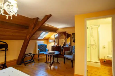 a living room with a table and blue chairs at Charme Hotel Hancelot in Ghent