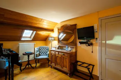a room with a desk and a chair and a television at Charme Hotel Hancelot in Ghent