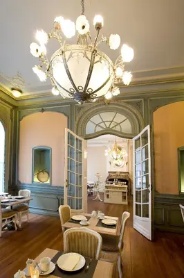 a dining room with a chandelier and tables and chairs at Charme Hotel Hancelot in Ghent