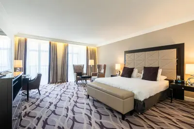 a large hotel room with a bed and a desk at Steigenberger Icon Wiltcher's in Brussels