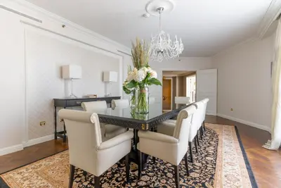 a dining room with a black table and white chairs at Steigenberger Icon Wiltcher's in Brussels