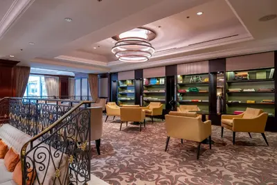 a hotel lobby with chairs and tables and a staircase at Steigenberger Icon Wiltcher's in Brussels