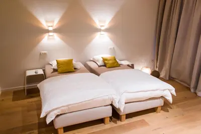 a bedroom with two beds with yellow pillows at Mon Dieu in Scherpenheuvel-Zichem