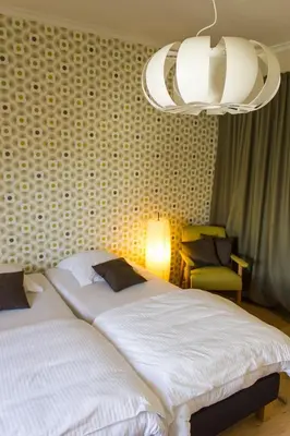 a bedroom with two beds and a chandelier at Mon Dieu in Scherpenheuvel-Zichem