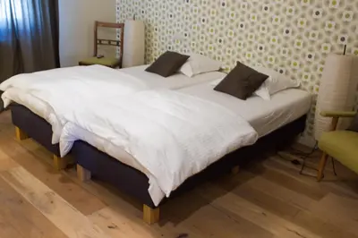 two beds with white sheets and pillows in a bedroom at Mon Dieu in Scherpenheuvel-Zichem