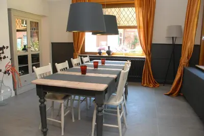 a dining room with a table and white chairs at Mon Dieu in Scherpenheuvel-Zichem