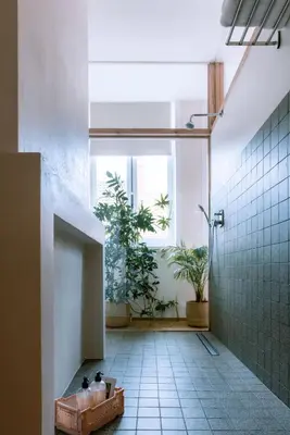 a bathroom with a shower and a tiled floor at Violet Suites in Ghent
