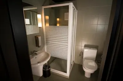 a small bathroom with a toilet and a sink at Hotel Chantecler in Brussels